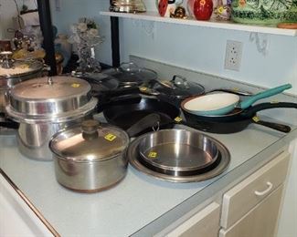 Notice the cute tea pots and clock on shelf above pots and pans.