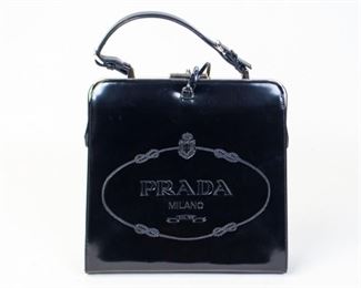56	Prada Logo-Embossed Spazzolato Frame Bag	Prada Top Handle Bag Black Patent Leather Silver-Tone Hardware Flat Handle Leather Lining & Three Interior Pockets Push-Lock Closure at Top Protective Feet at Base Includes Clochette Details Handle Drop: 5.25" Height: 11.25" Width: 11.50" Depth: 4" Some wear and scuffs - overall appears to be barely used.
