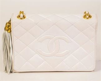153	Chanel White Leather Flap Bag Bijoux 1989	Chanel vintage white leather small flap bag, large stitched CC front, large leather tassel and gold-tone bijoux chain, white leather interior with a zipper pocket, some marks and discoloration from use, 5"H, 7 3/4"W, 2 1/2"D.
