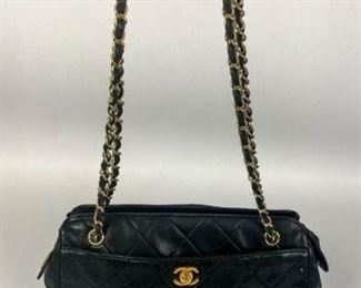 154	Chanel Quilted Handbag	Chanel quilted black caviar leather shoulder bag, interwoven gold tone chain link and leather shoulder straps, two exterior open pockets, zippered closure, interior has one open leather pocket, one zippered satin pocket with small hole, some pen marks on interior, some scratches, marks and wear on exterior from use, 8"H, 11"W, 4"D
