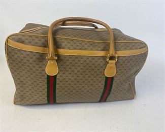 161	Gucci Weekend/Travel Bag	Gucci logo canvas and leather travel bag with rolled leather handles, exterior pocket, gold tone hardware, zippered closure, one interior zippered pocket, interior lining wear and deteriorating (needs to be relined), leather aging, marks and scuffs consistent with use,
