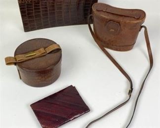 166	Grouping of Vintage Leather Goods	Lot includes Luc Benoit alligator clutch, single handle, snap closure, slip interior pocket, interior leather is worn, 7"H, 15"W, 2"D; snakeskin folio 5"H, 7"W; Assima crocodile leather binoculars case, marks and stains consistent with age and use, 7"H, 9"W, 3"D; round alligator handbag, leather handle with gold tone hardware, two flip up sides, one side of lid is partially separated from bag, suede lining, marks and wear consistent with age and use, 4"H, 7"Diameter
