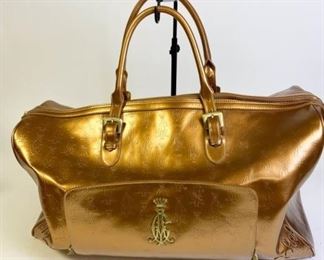 208	Christian Audigier Overnight Bag	Gold tone logo-embossed with double handles, lined with logo fabric with some wear, removable shoulder strap, good condition, measures 22 1/2"L x 11"W x 12"D
