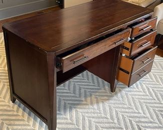 OFFICE DESK | Art deco style desk of nicely figured wood, with thin center drawer flanked by four side drawers; h. 31 x w. 52 x d. 24 in. [with surface wear as pictured]