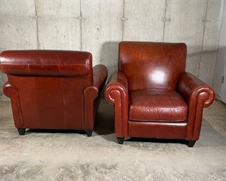 PAIR LARGE LEATHER CHAIRS | Rapallo Leather Company; pair of hardwood frame brown leather chairs complete with foot rest ottomans, four dark brown block feet on each piece; 38 x 42 x 42 in.; bottom lining loose on one foot rest 