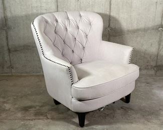 WINGED CLUB CHAIR | Cream colored fabric club chair with tufted backrest and tacked side accents, elevated on four square tapering legs; 33 x 32 x 36 in. [bottom lining torn] 