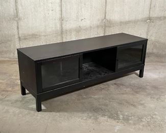 MEDIA CONSOLE | Dark stained wood TV stand with two glass window sliding doors, three partitions and removable shelving; 19-1/2 x 56-1/2 x 16-1/2 in. [some scratches to finish] 