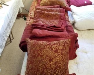 Queen comforter set with lots of pillows and a dust ruffle