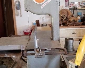 Meat saw for processing your own. Weed eater. Racoon in background.