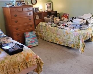Vintage maple chest on chest with twin beds. Once bed is equipped with an automatic adjustable feature. The items displayed on beds are "NEW" vintage linens along with other vintage gently used items. Tote with vintage and new purses. Another tote with vintage books, some children's.