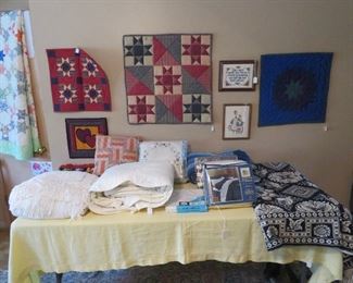 Lots of hanging quilts and bedding