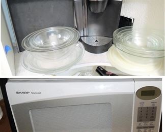Pyrex glass mixing bowls, Keurig coffee maker and pod storage, Microwave oven