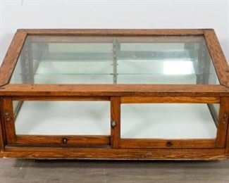 62	Museum Tabletop Display Vitrine	Museum tabletop display vitrine. American, Early 20th Century. Oak supports, glass top, sides, and sliding front doors that lock with included key. Two glass shelves. Light fixture is installed but has not been tested. Two foam core boards sit on top of slat bottoms. From the Salmagundi Club, the oldest artist's club in America. 21" H x 50" L x 30" D
