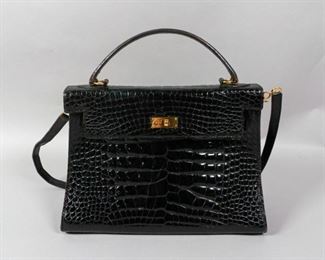 77	Vintage Balenciaga Crocodile Bag	Vintage Balenciaga handbag with gold hardware, velvet interior, detachable shoulder strap. Metal label on the interior. 9" H x 12 " L not including top handle. From the collection of the Salmagundi Club. Wear to the edges of the bag.

