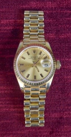 274	Ladies 18K Gold Rolex Watch	Ladies 18k yellow gold Oyster Perpetual date adjusted wrist watch. Marked on clasp 8570 Rolex Geneva Rolex sa 750 Swiss made (hallmarks) 18k. 67.4 grams. With extra links. Small flake in crystal between 12 and 1.
