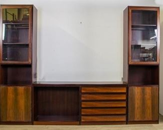 278	Scanflex Danish Modern Rosewood 3 Section Cabinet	Danish Modern 3 piece rosewood wall unit. Glass doors open to shelves. Center unit has 5 drawers on right side and open shelves on left side. 7 shelves not pictured. Overall: 112" L X 16" D X 84" H Credenza: 65 3/4" L X 16" D X 29 1/4" H
