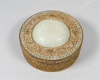 341	Chinese Bronze Box With Jade Inset	Round Chinese bronze box with white jade and turquoise insets on lid. Partial Hartman Trading Corp., NY label on underside. Box 3 3/4"H x 9"-diameter; jade inset approximately 5"-diameter. Wear and oxidation to patina, some turquoise missing.
