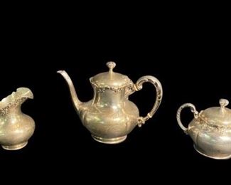354	Towle Sterling 3 Piece Tea Service	A Towle sterling silver teapot, lidded sugar, and creamer. Each decorated with scrollwork on rims and handle. All marked on the underside with Towle pictorial mark , "Sterling" and "7619". Weight includes decorative bone bands on handles. Teapot: 7" H x 8 1/4" W. 736.2 Grams. Sugar Jar: 4 1/2" H x 7 1/4" W. 484.8 Grams. Creamer Jug: 4 1/2" H x 4 1/2" W. 315.2 Grams. 1536.2 grams in total.
