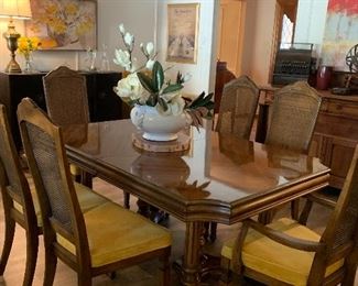 The dining room table has a leaf and seats 6 people comfortably.  The chairs are in perfect condition and do not need to be recovered. be sure and look for the matching china cabinet.