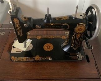 antique sewing machine in oak cabinet
