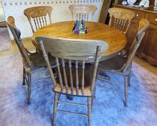 Round oak table w/ 6 high back carved chairs and 2 leaves