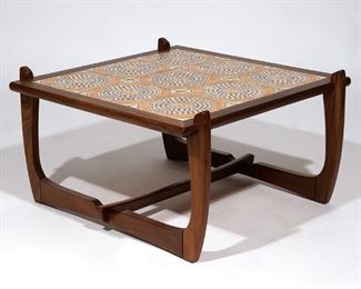 Lot 56 | MID-CENTURY LOW TABLE | Mid-century modern wood frame table decorated with an inset tile top of circular design; h. 16 w. 29-1/2 d. 28 in.
