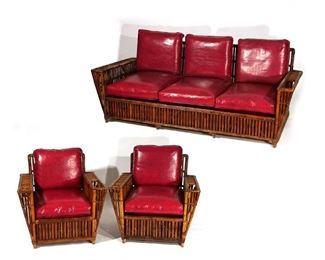 Lot 58 | (3PC) NANTUCKET STICK RATTAN SOFA & ARMCHAIRS | New York, circa 1930s, rattan and bamboo, comprising a sofa and two lounge chairs, all with arms having recessed drink and magazine holders, with original Manhattan Rattan Co. label (see photo); h. 31 w. 85 d. 35 in. (sofa)