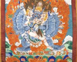 Lot 64 | TIBETAN THANGKA | Depicting a many-armed blue god embracing its consort and wreathed in flames, inscribed on verso, with silk embroidered surround and cloth cover; h. 29 w. 19-1/2 in. (subject); overall: 49 x 32-1/2 in.