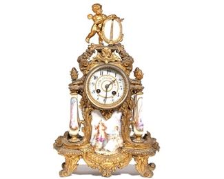 Lot 136 | LOUIS XVI-STYLE ORMOLU & PORCELAIN MANTEL CLOCK | French mantel clock with porcelain floral-painted dial with Arabic numerals over a painted porcelain plaque with courting scene, having four porcelain pillars painted with country scenes topped with acorn finials, all mounted in a scrollwork ormolu case crested by a cherub finial; the movement stamped "MADE IN FRANCE" with a "B D" crest stamp and "Medaille D'Argent Vincene & Cie. / 1855" mark; h. 17 w. 10 in.
