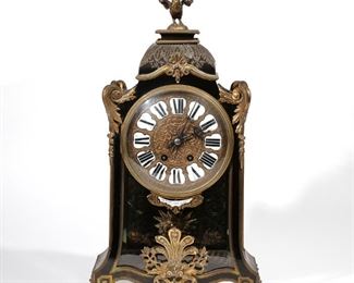 Lot 137 | CHARLES OUDIN LOUIS XIV-STYLE BRACKET CLOCK | Mid-19th century, tortoiseshell and ebonized wood with Boulle inlay, scrolling acanthus leaf ormolu mounts and a fan device before the front glass panel, having a rooster finial over an inlaid brass garland motif, the embossed bronzed face with Roman numeral enamel plaques and a border of stamped seconds markers, the interior with a miniature brass parquetry floor, and with brass inlay scrollwork to the interior of the door, having Greek keys over the feet; with white enamel plaque below the face, "Ch. Oudin Horloger de la Marine ... Paris"; the movement marked "Medaille D'Argent Vincentie & Cie 1855" and numbered 1154 . 7. 2; h. 20-1/2 w. 11 d. 4-3/4 in.