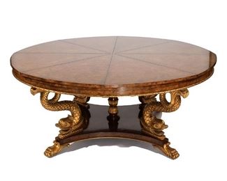 Lot 144 | BURL WALNUT "JUPE" RADIAL EXTENSION TABLE | Smith & Watson, 20th century, having carved gilt dolphin supports on raised platform resting on gilt paw feet; h. 30 dia. 96-1/2 in.