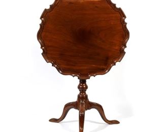 Lot 145 | PHILADELPHIA PIE-CRUST TILT-TOP TEA TABLE | Late 18th/early 19th century, having a single-piece carved pie crust top hinged to an open "birdcage" frame, resting on a pedestal with suppressed ball carving, tripod legs decorated with acanthus leaves resting on pad feet; h. 28 w. 27-1/4 d. 27-1/2 in.