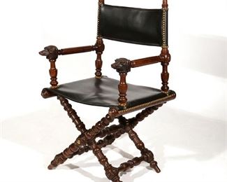 Lot 147 | 19TH C. RENAISSANCE REVIVAL FIGURAL CAMPAIGN CHAIR | Circa 19th century, mahogany with overall carvings, having figural dog-head hand holds and studded leather upholstery; folding
h. 38 w. 21 d. 20 in. n.b. for a similar folding arm chair, c. 1860: from the "Industrial Design" exhibit at the Grand Palais, ref. Styles of American Furniture, 1860-1960 by Eileen and Richard Dubrow, pg. 41