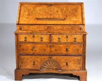 Lot 149 | GEORGE II INLAID SLANT BURL DESK OF PREFERRED SIZE | Circa 1740, George II burl wood desk of small size, two-piece construction, exceptional fitted interior with well and inset leather writing surface, with two half drawers over two full width drawers, the lower drawer with concave sunburst in contrasting inlaid woods; h. 39 w. 35 d. 21 in.
