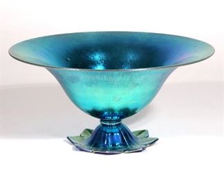 Lot 239 | STEUBEN BLUE AURENE FOOTED BOWL | Onion skin surface, pedestal with shaped pedal foot, signed "Steuben Aurene" and no. 6058
h. 5-1/2 dia. 12 in.
