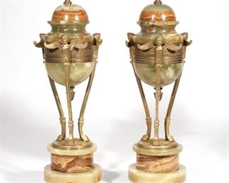 Lot 241 | PAIR LOUIS XVI-STYLE ONYX & ORMOLU GARNITURES | Urns of green onyx and rust-colored banded agate, supported on three paw feet terminating in the bust of a winged figure, the urns with acorn-form finials, resting on a multi-tiered pedestal of onyx and agate, all over three metal feet
h. 17-3/4 dia. 5 in. n.b. the "lids" appear to be fixed