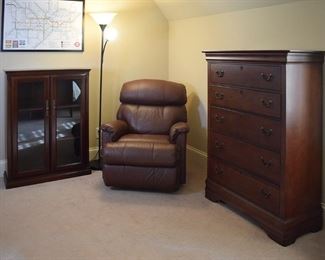 chest of drawers, leather recliner, floor lamp, display case