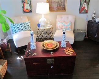 Lovely accent chairs, beautiful red trunk, decor pillows throughout & art