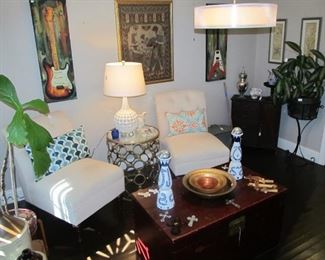 Lovely accent chairs, beautiful red trunk, decor pillows throughout & art