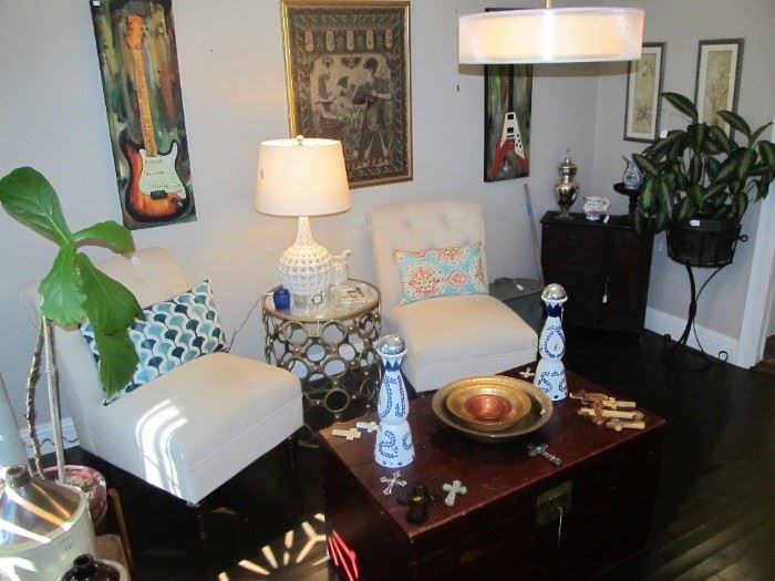 Lovely accent chairs, beautiful red trunk, decor pillows throughout & art