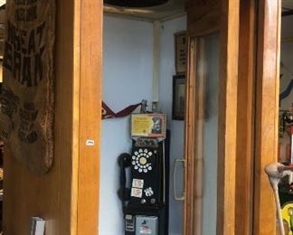 1940s Wooden Phone Booth with vintage advertisement above phone.