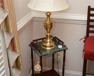 marble and wood two tiered table, single brass lamp, flat screen tv