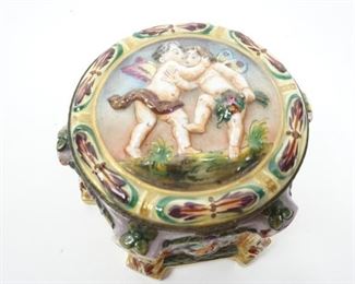 VINTAGE PORCELAIN CAPODIMONTE OCTAGONAL JEWELRY VANITY DRESSER BOX CASKET CHERUB  $156 plus shipping                
DETAILS:
Vintage (mid- to late- 1900) 
Porcelain Capodimonte 
Jewelry Box / Vanity Dresser Casket 
Hinged
Hand Painted 
Deep High-relief Putties Cover and Regional Symbolic Items (i.e. fruits, veggies, poultry, etc.) Decorated the Box Throughout
Bronze Ormolu Style Mounted Hinge and Ram Head Clasp
Octagonal Shaped
Made in Germany
Measurement: 4" x 3"