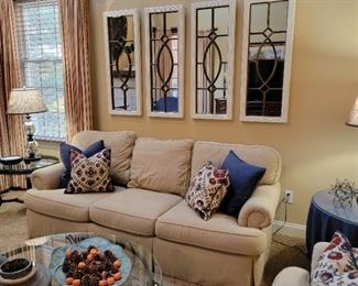 Beige three-cushion sofa. 32" high x 80" long x 38" deep.