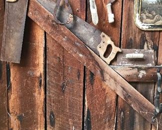 Vintage hand saws, scythes, tongs