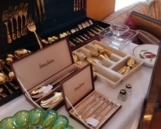 Three sets of gold colored flatware and 4 sets of stainless