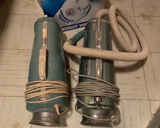 Vintage vacuums with attachments.