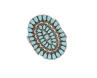 6106
A Large Zuni-Style Cluster Bracelet
Second-Half 20th Century
Appears unmarked
A three wire cuff with a large central oval plaque of cluster set treated turquoise cabochons
6.875" total inner C x 3.75" H, wrist opening: 1"
72.8 grams
Estimate: $200 - $400
