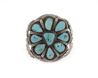6110
A Carl Begay Navajo Silver And Turquoise Cluster Bracelet
Second-Half 20th Century, Diné
Stamped: C / [partial sun pictograph for Carl Begay]
A three wire backing cuff set with nine turquoise stones, the central plaque flanked by holly leaves and berry
6.5" total inner C x 2.625" W, wrist opening: 1.125"
105.7 grams
Estimate: $400 - $600