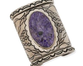 6118
A Danice Benally Southwest Silver Cuff Bracelet
Second-Half 20th Century
Etched: Danice Benally / [artist's cipher]
A wide silver cuff with raised edges and overall stamped design set with a large oval purple charoite stone
6" total inner C x 3.125" H; wrist opening: 0.875"
197.2 grams
Estimate: $400 - $600